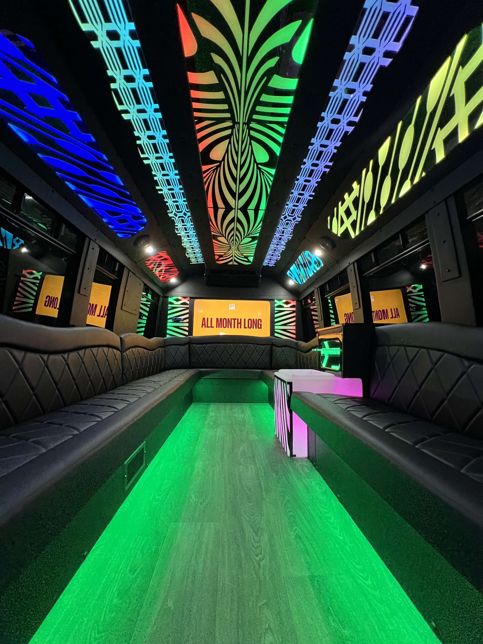Interior of a luxury party bus with ambient lighting and plush seats.